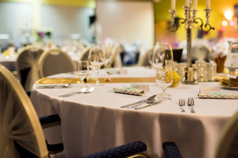 Formal banquet table setup with white tablecloth, wine glasses, and candelabra featuring linens cleaned by commercial laundry service in Fort Worth